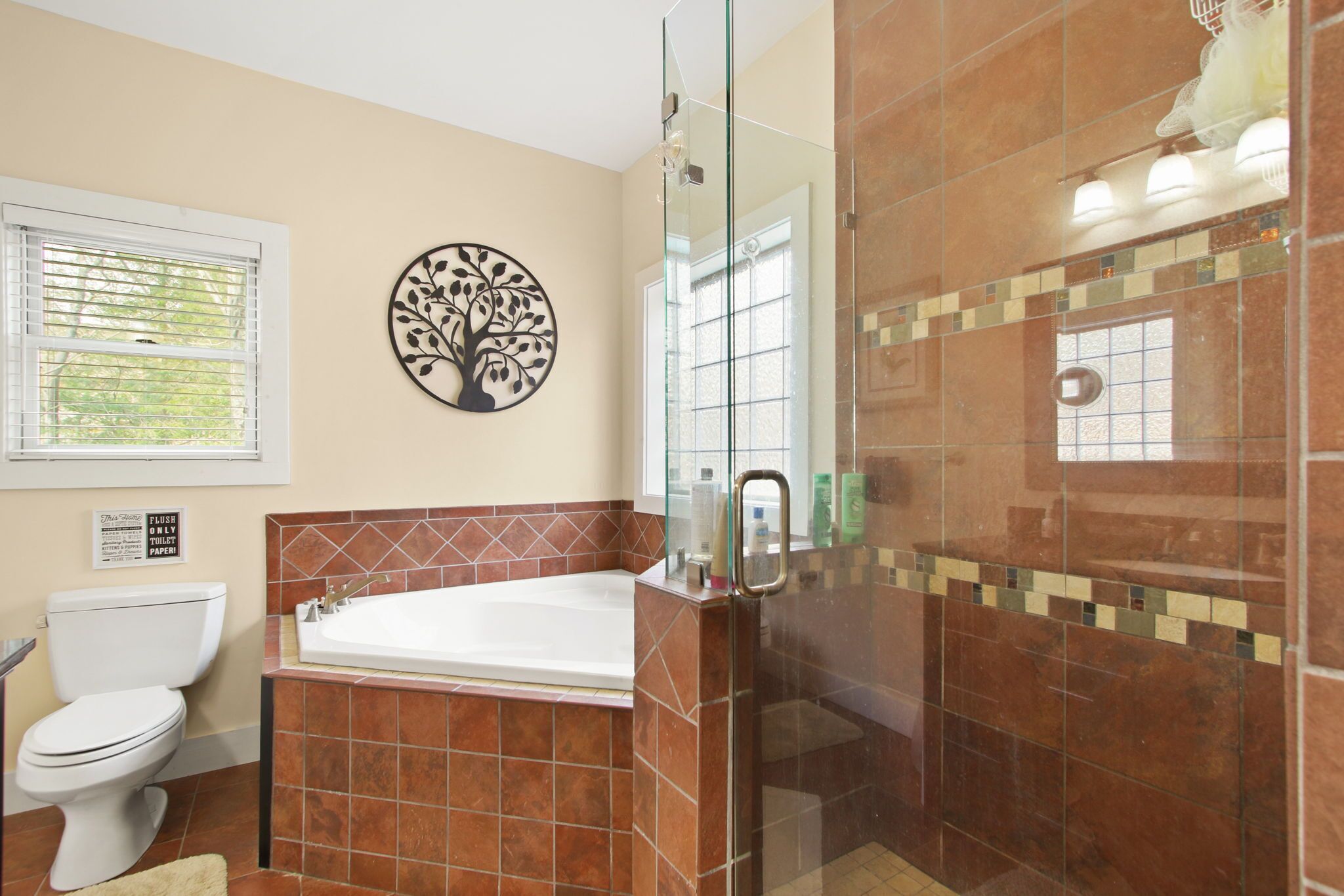 A bathroom with a toilet, a bathtub, and a glass shower enclosure.