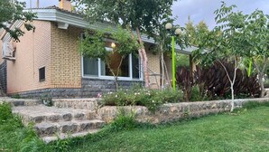 A house with a brick exterior, a stone staircase leading to the front door, and a well-maintained lawn. - Villa De Anna (St.-Rémy-de-Provence)