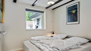 A bedroom with a bed, a window, a nightstand, a lamp, and a painting on the wall. - 3 bedroom amazing home in Lundby (Lundby)