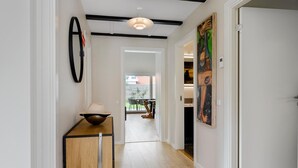 A hallway with a wooden bench, a hanging light fixture, and a painting on the wall. - 3 bedroom amazing home in Lundby (Lundby)