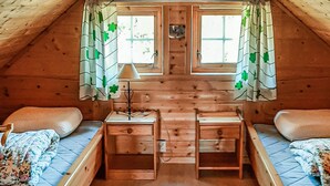 A cozy attic bedroom with two beds, a small desk, and a window with curtains. - Stunning home in Korssund with WiFi (Korssund)