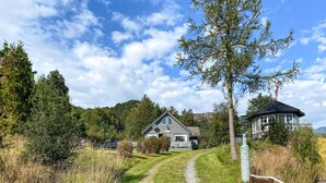 A house with a gravel driveway leading to a front porch, surrounded by trees and a clear sky. - Stunning home in Korssund with WiFi (Korssund)