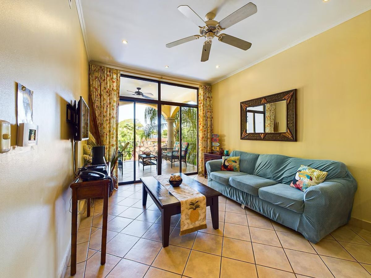 A spacious living room with a sofa, a coffee table, and a television.