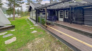 A wooden deck with outdoor seating and a tent.