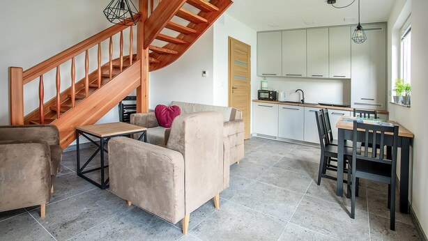 Ein modernes Interieur mit einer Holztreppe, einem Essbereich und einer Küche.
