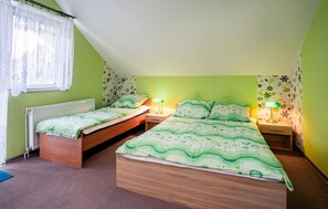 Une chambre avec deux lits simples, une fenêtre avec des rideaux légers et un radiateur.