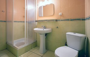 Une salle de bain avec une douche, un lavabo et des toilettes.