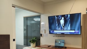 Une chambre moderne avec un lit, un bureau avec un ordinateur portable, une télévision et une chaise.