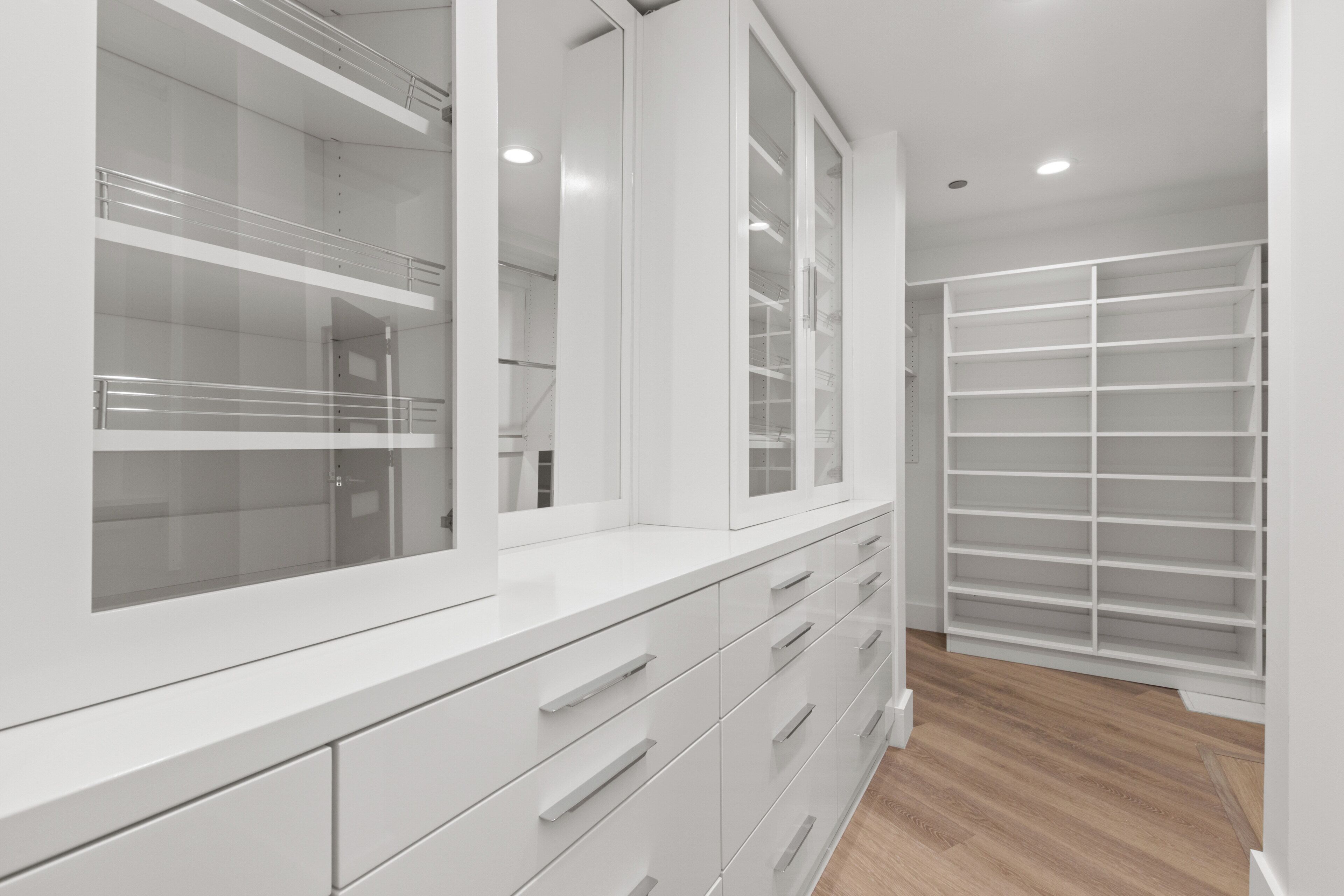 Un intérieur moderne et épuré, de couleur blanche, avec un placard intégré et un grand miroir.