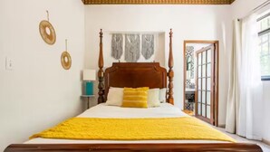 A four-poster bed with a yellow bedspread, a wooden headboard, and two pillows. - Historic Condesa Mansion • Spacious Private Home for Families & Groups (Ciudad de México)
