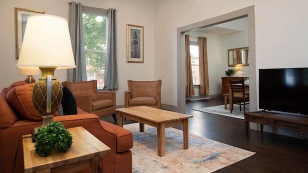 A modern living room with a sofa, armchair, coffee table, and TV. - Division Ave East Lake Update (Birmingham)