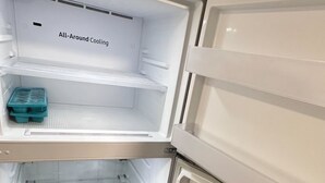 An open refrigerator with two shelves and a freezer compartment. - 12th Ave The Bricks - Unit 5 (Birmingham)