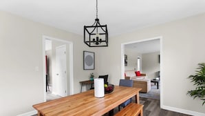 A dining area with a wooden table, benches, and a hanging light fixture. - Dugan Ave Dugout - Unit A (Birmingham)