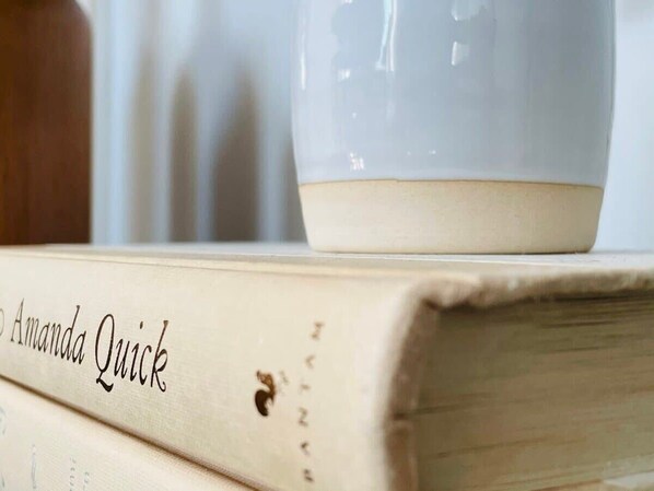 A stack of books with the top book titled "Amanda Quick". - 83rd Street Comfy Cottage (Birmingham)