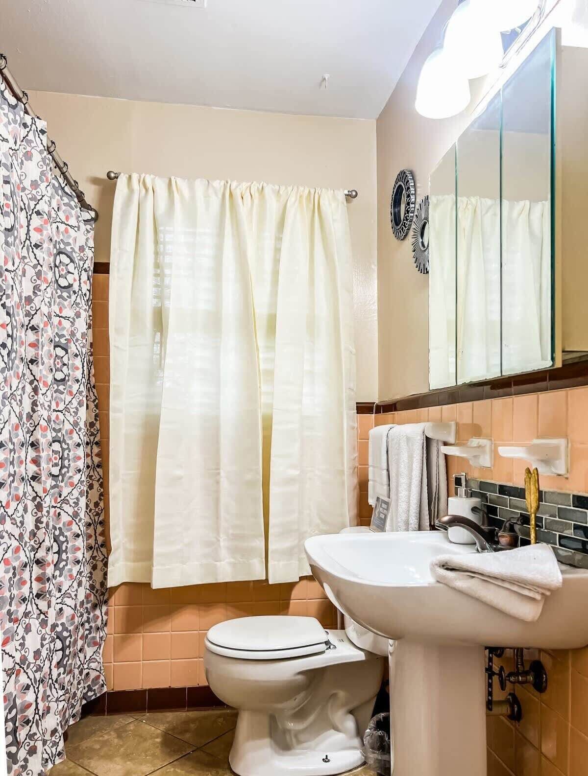 A bathroom with a toilet, sink, and a shower curtain.