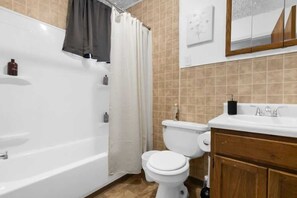 Ein modernes Badezimmer mit Badewanne, Toilette und Waschtisch.