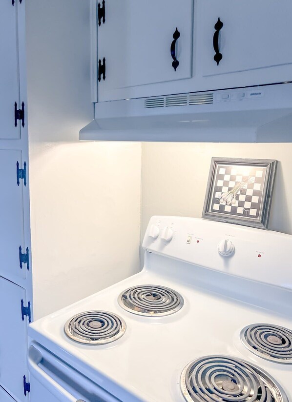 Une cuisinière blanche dotée de quatre brûleurs et d’un panneau de commande.