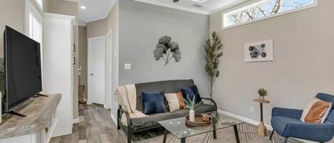 A modern living room with a sofa, coffee table, and TV.