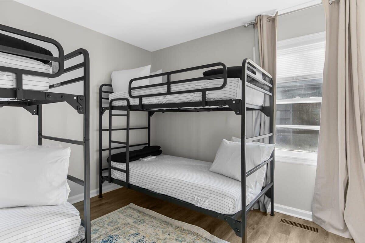 A bunk bed room with a window and curtains.