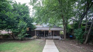 A covered patio area with a concrete pathway leading to a seating area. - Highland Drive Hideaway (Birmingham)