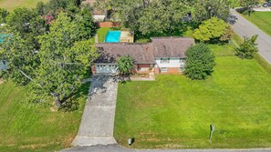 An aerial view of a residential property with a swimming pool, a detached garage, and a well-maintained lawn. - Gilmore Retro Pad (Madison)