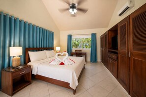 A hotel room with a bed, a desk, a chair, a TV, and a wardrobe.