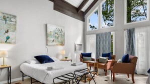 A bedroom with a bed, two chairs, a table, and artwork on the walls. - Observatory Drive Terrace House (Birmingham)