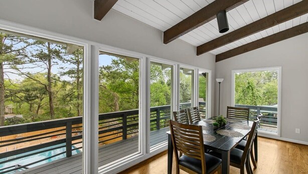 A dining area with a view of a swimming pool and trees. - Observatory Drive Terrace House (Birmingham)