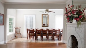 A dining area with a wooden table and chairs, a fireplace, and a mirror on the wall. - Arlington Crescent Revival - Unit 1 (Birmingham)