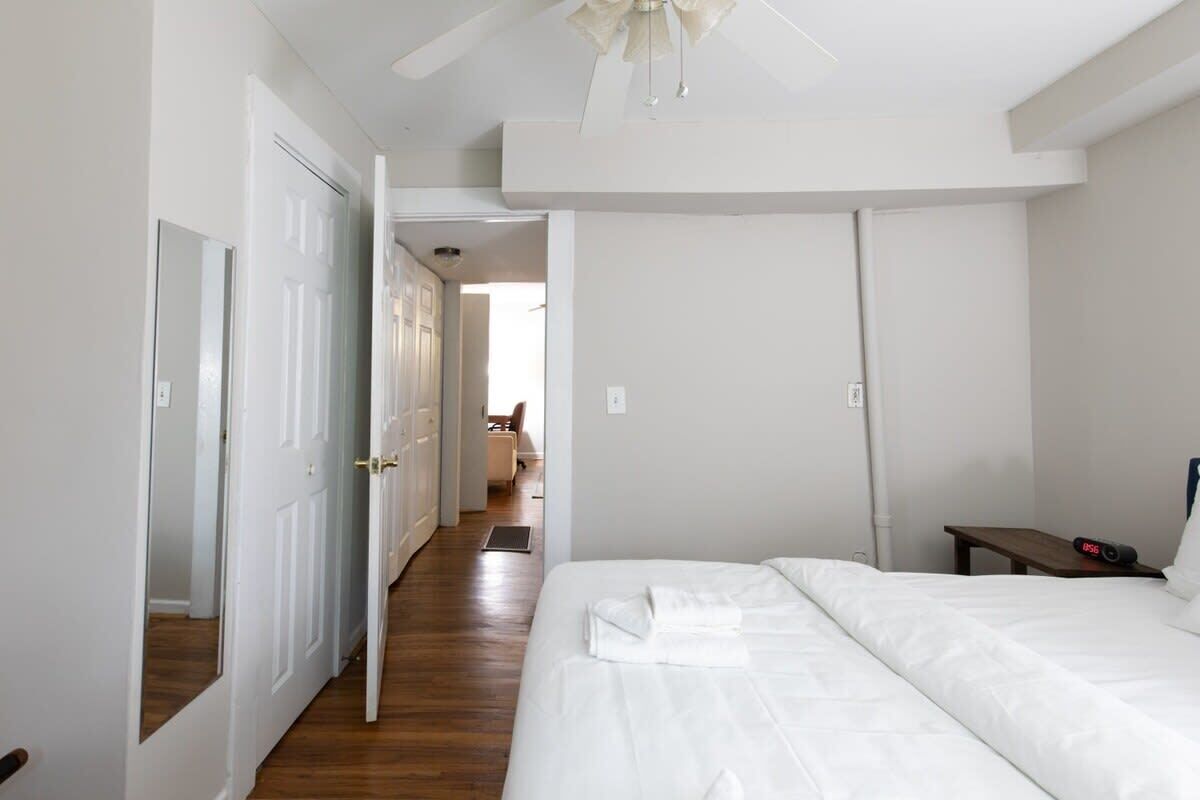 A hotel room with a large bed, a bedside table, and a ceiling fan.