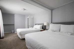 A hotel room with two beds, a bedside table with a lamp, a wardrobe, and a carpeted floor. - 4th St Little Blue in Bham (Birmingham)