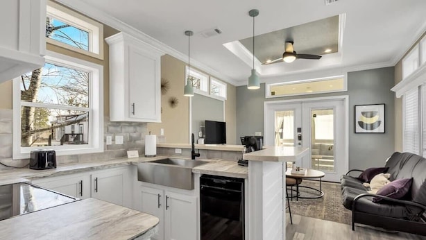 A modern kitchen with white cabinets, a built-in dishwasher, and a large window. - Byrd 7 Nesting Nook (Owens Cross Roads)