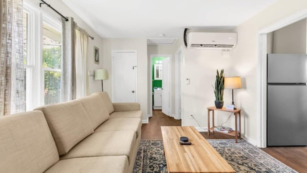 A modern living room with a beige sofa, a wooden coffee table, and a patterned rug. - 12th Ave The Bricks - Unit 4 (Birmingham)