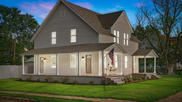 A two-story house with a front porch, a small attached garage, and a well-maintained lawn. - Bradley Blissful (Huntsville)