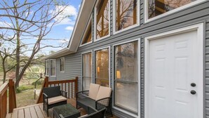 A covered deck with wicker furniture and a white garage door. - Valley Lake Gem (Birmingham)