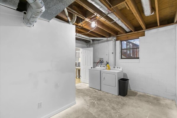 A laundry room with a washing machine, dryer, and a trash can. - Valley Lake Gem (Birmingham)