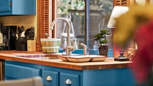 A kitchen with a wooden countertop, a sink, and a window with blinds. - Eastview Drive Jolly Green Giant (Madison)