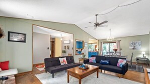 A spacious living room with two sofas, a coffee table, and a ceiling fan. - Eastview Drive Jolly Green Giant (Madison)