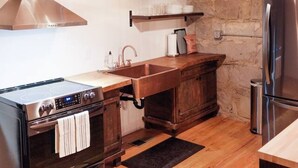 Une cuisine équipée d’une cuisinière, d’un four et d’un réfrigérateur en acier inoxydable.