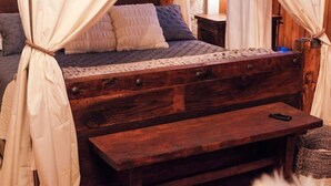 A bed with a wooden headboard, a bench, and a canopy. - The Scandinavian West Hall—Near Anthony Lakes! (North Powder)