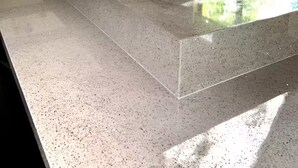 Una cocina moderna con una isla grande, electrodomésticos integrados y vistas a zonas verdes por la ventana.