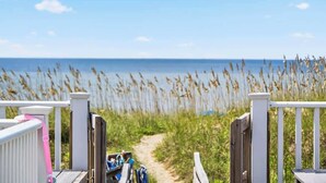 A wooden deck leading to a beach with a clear path and a view of the ocean. - Just A Touch by Brunswick Vacation Rentals: 6BR Oceanfront Retreat, Sleeps 16 (Ocean Isle Beach)