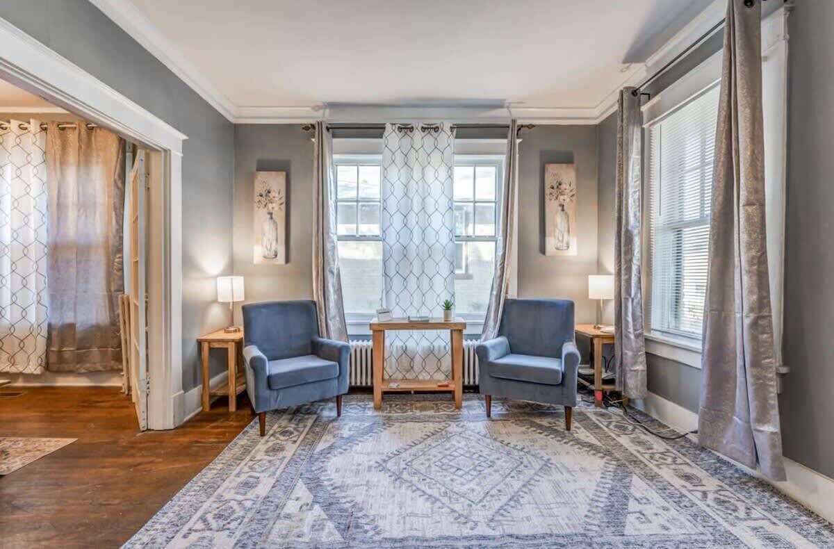 Une pièce comprenant deux fauteuils, une petite table et un tapis à motifs.