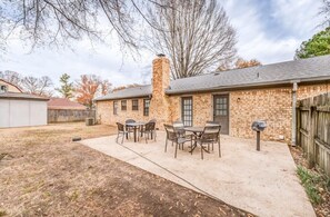 A brick building with a chimney, a patio with chairs, and a mailbox. - Hardwood Guesthouse (Cordova)