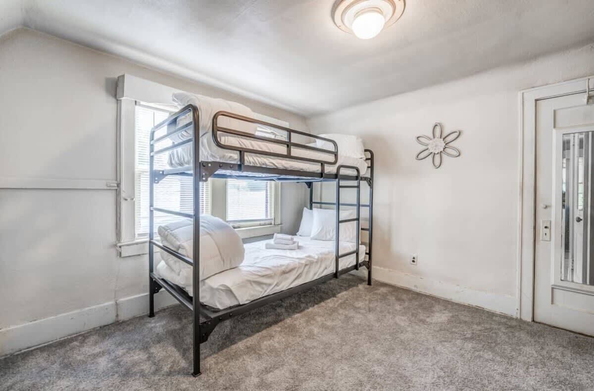 Habitación con literas, una ventana, una puerta y un adorno en la pared.