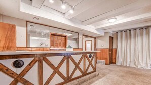 Una camera d'albergo con una scrivania in legno, un grande specchio e vista sull'esterno.