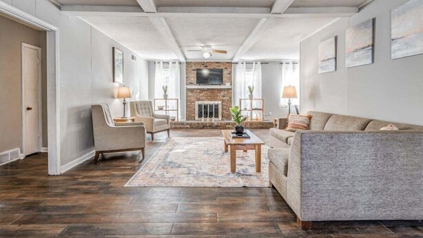 A spacious living room with a fireplace, a sofa, a coffee table, and two lamps. - Yale Gather Hideaway (Memphis)