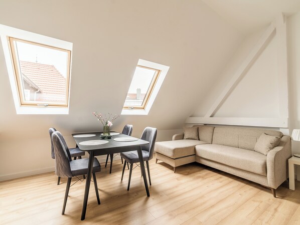 A modern loft apartment with a dining area, a sofa, and a skylight. - Wilson Park Serene Studio #4 (Poznań)