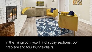 A living room with a sectional sofa, fireplace, and lounge chairs. - NWA Getaway Pool, Arcade, Trails (Springdale)