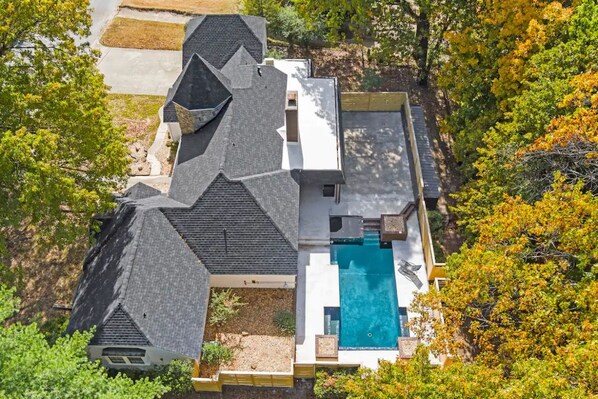 A house with a large swimming pool, surrounded by trees and a well-maintained lawn. - NWA Getaway Pool, Arcade, Trails (Springdale)